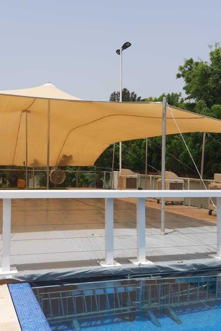 הצללה מתוחה ליד בריכה
